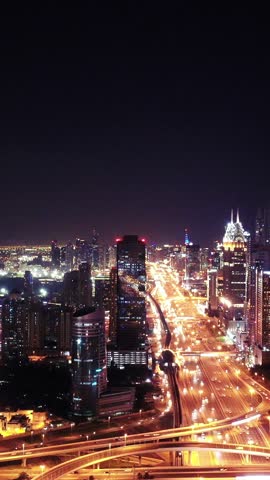 Night view of iconic skyscrapers and busy traffic on a major interchange in Downtown Dubai, UAE. Stunning skyline of a modern city, symbolizing business, finance, and urban development