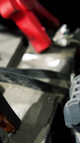 Close up of charging car battery with electricity trough cables at the car service. Action. Concept of repair, professional electric equipment.