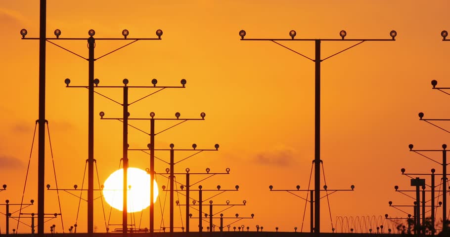 Airplane landing in airport at sunset.