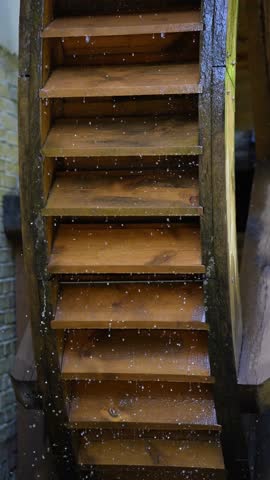 Rotation of wooden wheel of antique water mill close-up.
