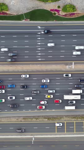 High-angle aerial top view of dense traffic flowing on multilayered highways and overpasses in Dubai at rush hour. Modern urban infrastructure, transport network, and daily city commute concept