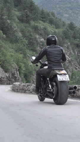 Motorcyclists drives our powerfull bikes on mountain serpentine in Monaco. Footage. Bottom View from a motorcycle. Couple of choppers with pilots in helmets descend in slow motion.