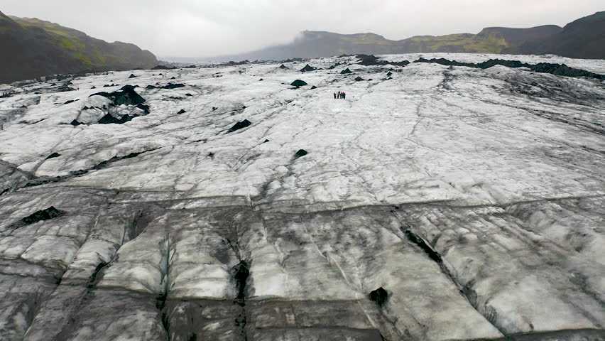 People hiking with crampons on the Solhrimajokull glacier in southeast Iceland.