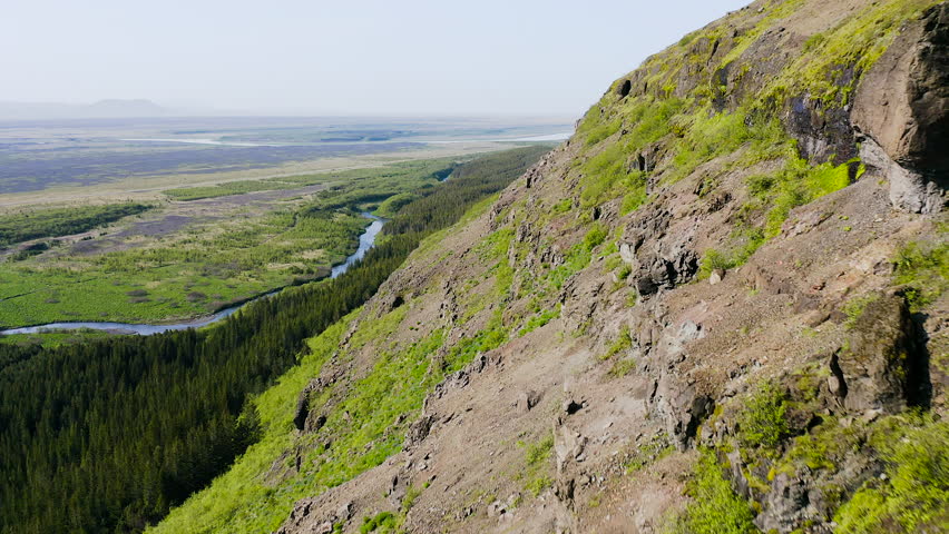 Aerial view of spruce forests and hills in Iceland.