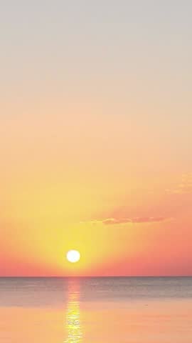 The setting sun paints the evening sky with a fiery red sunset, vertical video copy space