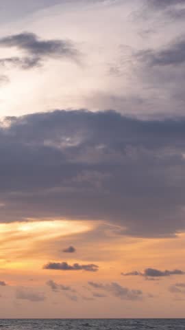 The sky at sunset is a vibrant canvas of colors. Wispy clouds, painting a masterpiece of golden hues, fiery oranges, and serene blues, casting a spellbinding display that fills the vertical video time