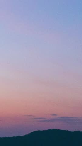 time lapse reveals the dynamic play of light and shadow, showcasing a canvas of clouds against the vibrant hues of sunrise. Climate concept.Vertical copy space