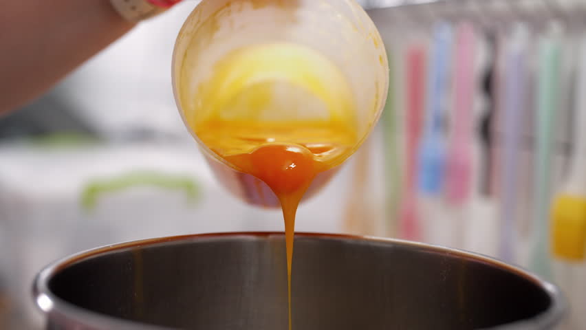 Yellow yolks are added in metal stand mixer bowl. Whipping eggs for baking