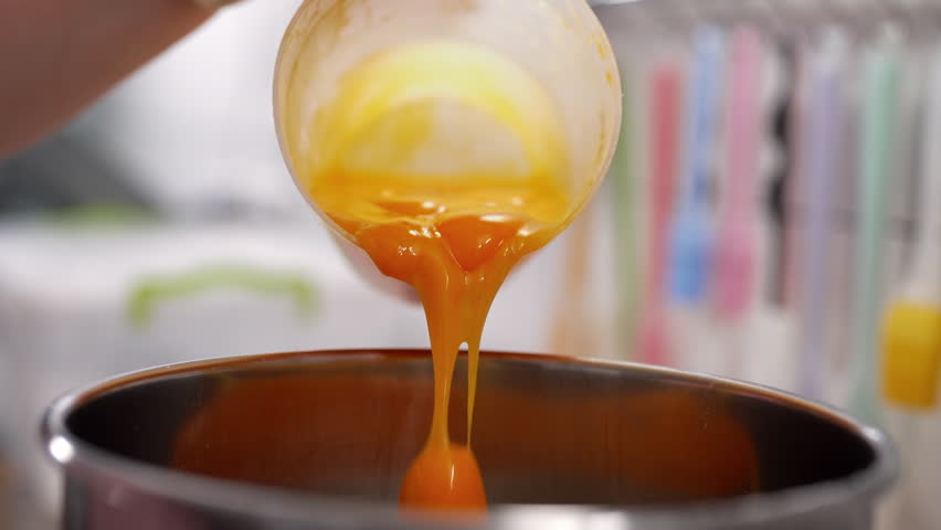 Yellow yolks are added in metal stand mixer bowl. Whipping eggs for baking