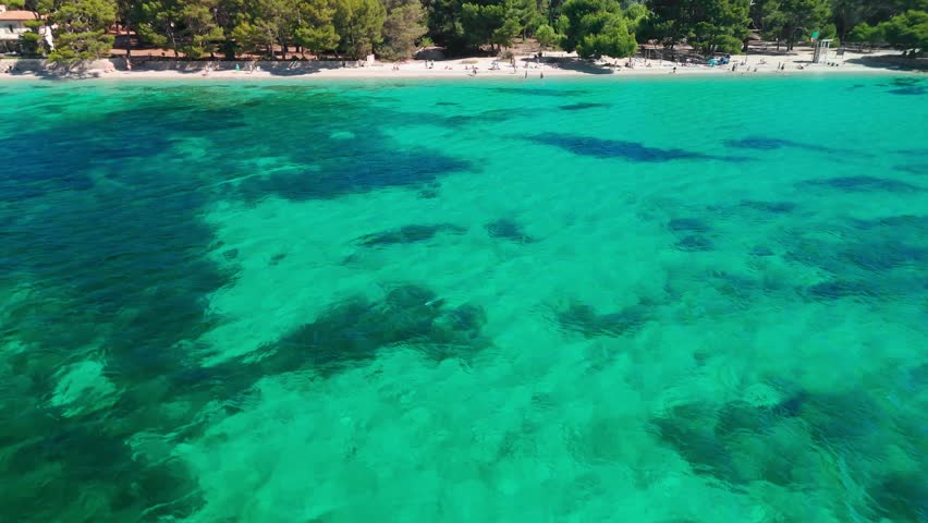 Aerial view of Playa de Formentor at Cala Pi de la Posada bay in Mallorca. Stunning beach with people swimming in turquoise waters at Cap Formentor, Majorca, Balearic Islands, Spain.