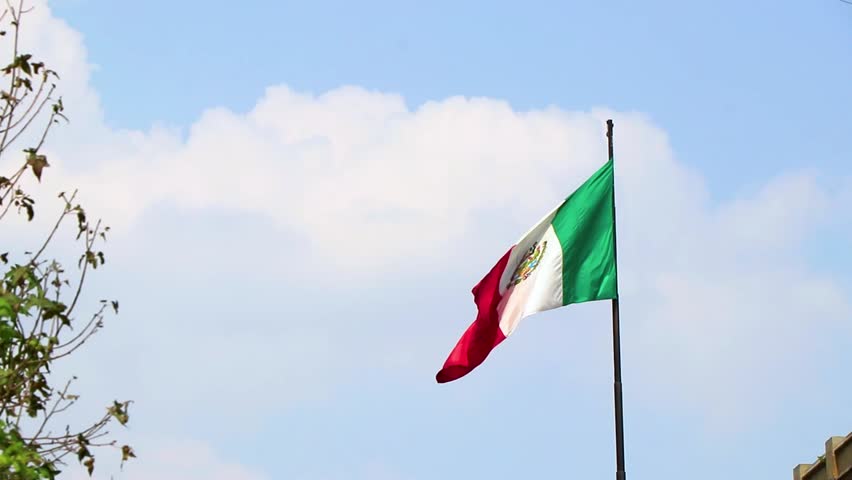 Mexican flag green white red with blue sky in Centro Historico Mexico City Mexico.