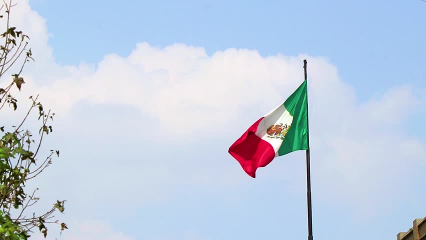 Mexican flag green white red with blue sky in Centro Historico Mexico City Mexico.