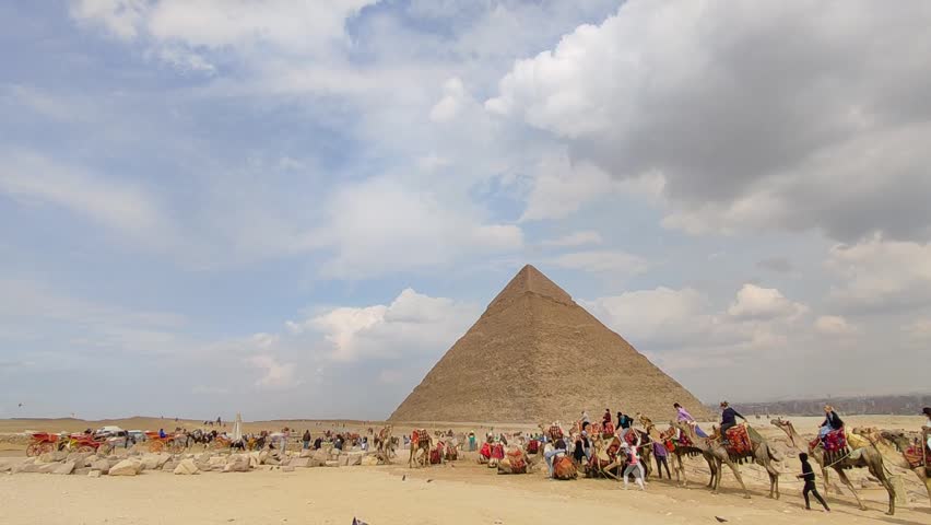 Giza, Egypt - March 9, 2025:  Giza Pyramid Complex in Egypt, view from the desert with tourist on a camel ride trip around the pyramids.