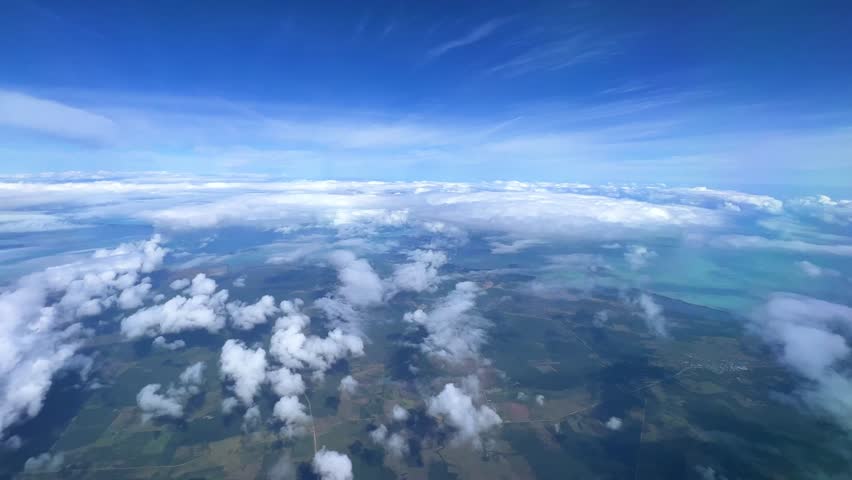 VARADERO, CUBA - DECEMBER 20, 2023: View from the porthole on the Atlantic coast of Cuba. View of the turquoise ocean water and islands with snow-white sand from the plane. White clouds over the water