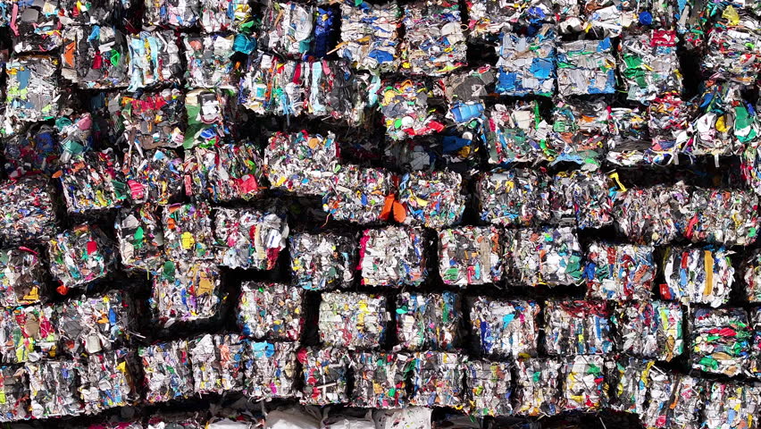 Recycling process showing compacted bales of mixed plastic waste at facility