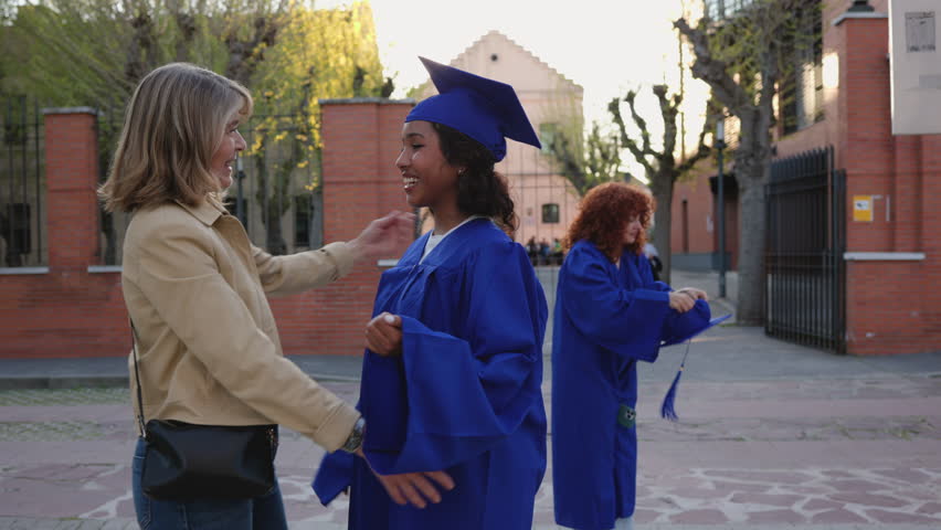 Emotional graduate in academic gown hugging proud mother after receiving degree, capturing moment of familial love and academic accomplishment during university graduation ceremony