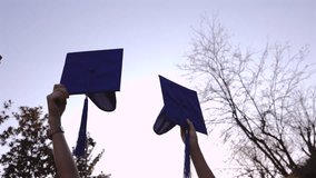 Joyful graduates in academic gowns celebrating educational milestone by throwing graduation caps high, marking successful completion of studies and new life chapter - Powered by Shutterstock - Get 15% off with code: PIKWIZARD15