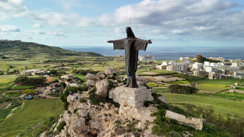 Aerial view of the stunning Gozo Island in Malta showcasing the Christ the Redeemer statue and picturesque landscapes