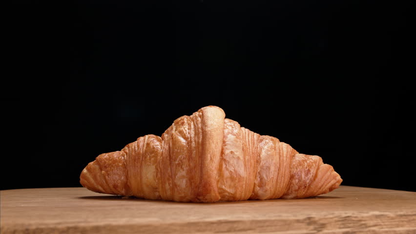 Delicious traditional croissant with a crispy golden texture. The croissant spins around itself and chocolate is slowly poured into it. A video that will whet your appetite.