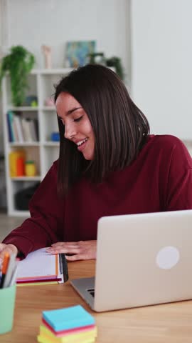 Young woman taking notes while working from home