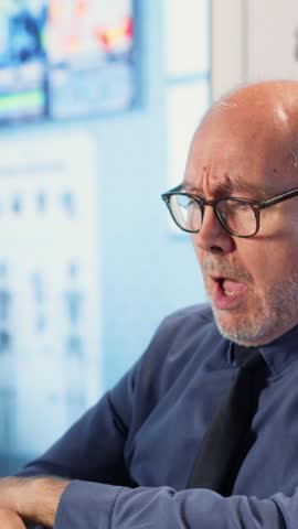 Vertical Video Male wheelchair user with a respiratory problem coughing at checkup, suffering from asthma or pneumonia during medical consultation. Medic helping old man with infection. Camera B.