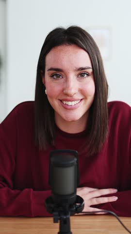 Young woman recording podcast at home