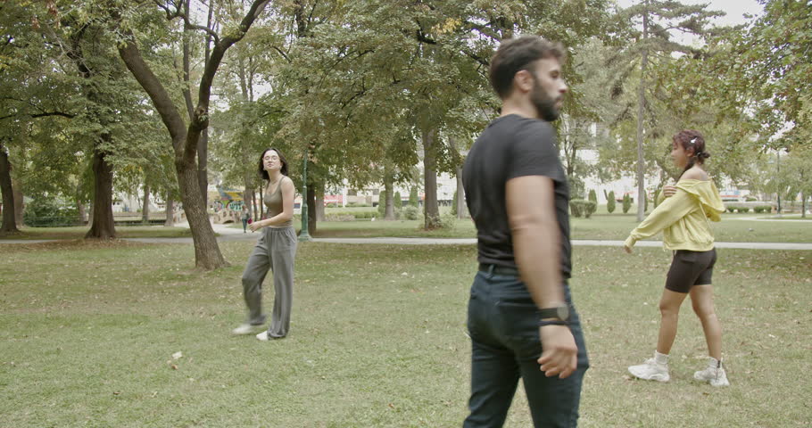 Students and their professor doing sport exercises in the park. They are stretching, warming up, and enjoying their time together.