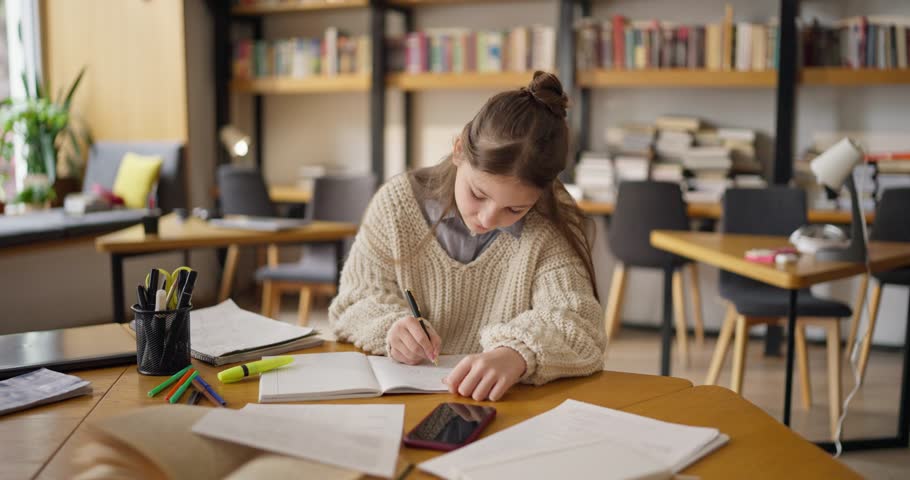 Young Girl Studying in a Sunlit Library, Smiling at the Camera