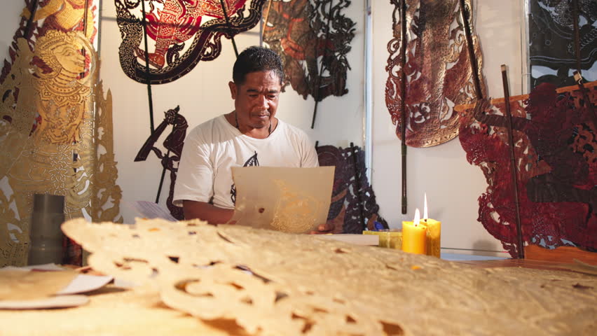 Craftsmen create traditional Thai Khon puppets.