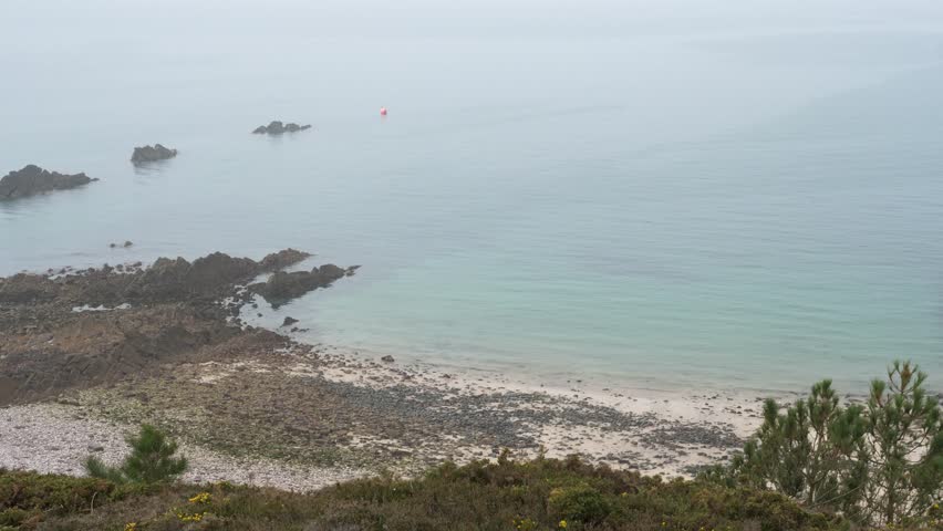 Erquy, France - March 26, 2025: An aerial view of the coastline on a foggy day.