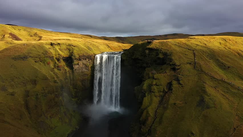 Skogafoss waterfall flowing through green cliffs in Iceland