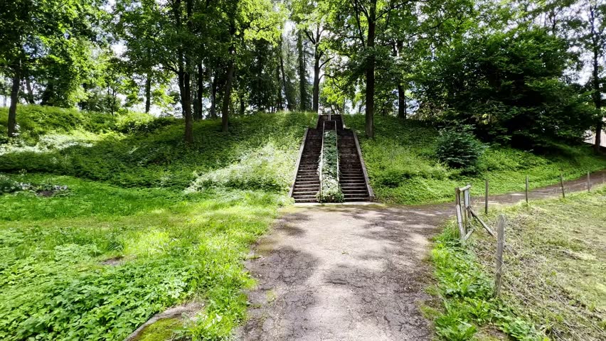 Stone steps on a hill in a landscape park in summer. Slow motion. Latvia