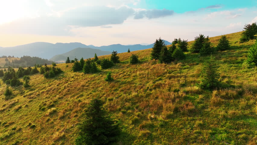 Cinematic 4K drone shot of sunset over Veľká Fatra mountains in Slovakia with scenic forest, ridges, and golden sky.