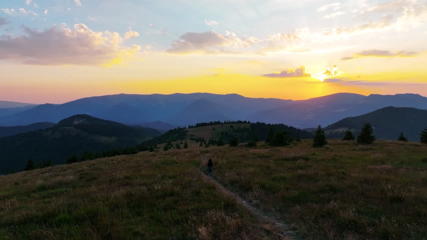 Vibrant hues of sunset illuminate the Veľká Fatra mountains in Slovakia. Drone captures the play of light over the landscape.