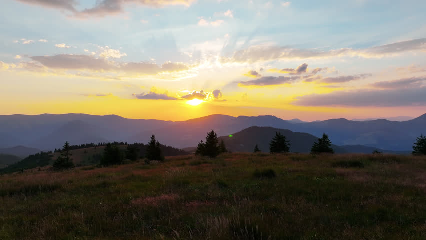 Golden sunset over the Veľká Fatra mountains in Slovakia. Drone captures Krížna peak and distant Donovaly resort in soft evening light.
