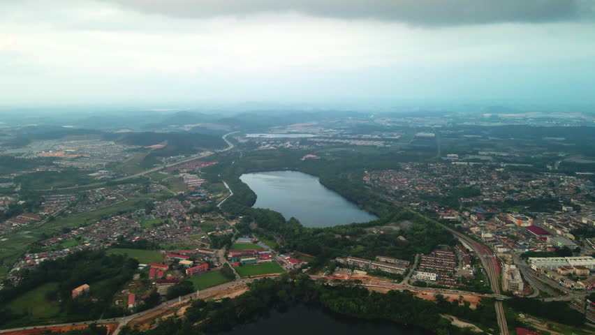 Aerial view of a large lake surrounded by residential and urban areas. Captured by drone from high altitude. Suitable for environment, landscape, and urban development projects.