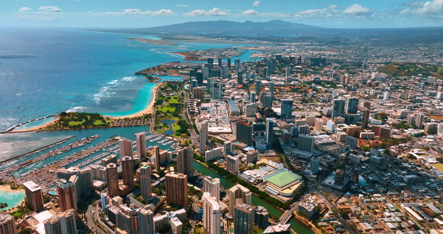 Highly populated coastline of the Pacific Ocean in Honolulu, Hawaii, USA. Waikiki district at foreground. Mountain range at backdrop. Aerial view.