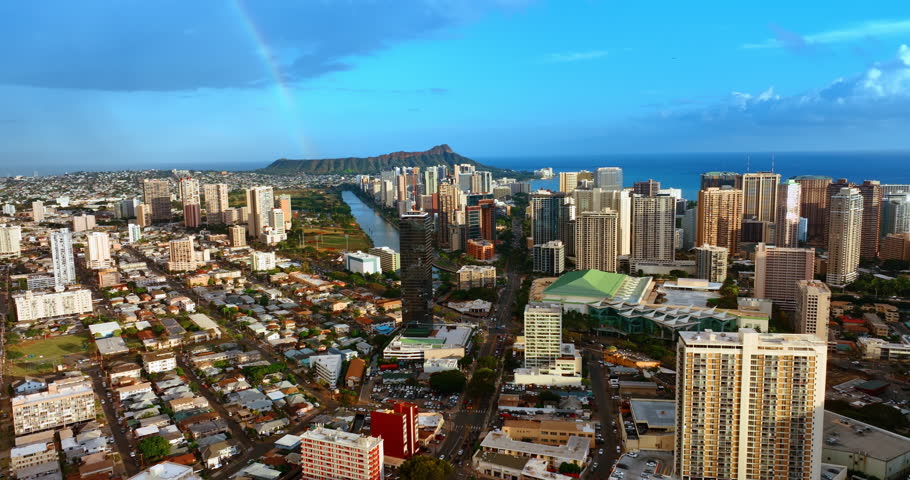 Diverse cityscape of modern Honolulu, Hawaii, USA. Drone footage approaching Waikiki district. Diamond Head Crater at backdrop.