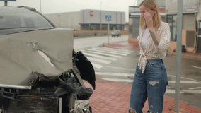 Distressed female driver standing beside damaged car after traffic collision, hands covering face, expressing overwhelming emotional strain - Powered by Shutterstock - Get 15% off with code: PIKWIZARD15