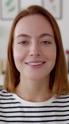 Vertical HD video. POV woman talking with colleague on laptop video call from living room. Pretty millennial female having a conversation through online meeting. Technology lifestyle concept