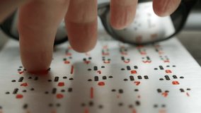 Close-up of a fingertip reading braille on a white page with sunglasses nearby. - Powered by Shutterstock - Get 15% off with code: PIKWIZARD15