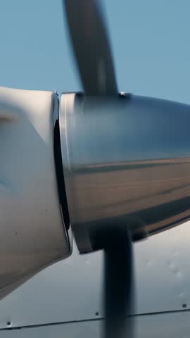 Close-up view of rotating propeller engine of twin turbo light airplane. Side view of spinning blades