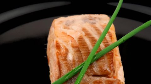 healthy fish cuisine : baked pink salmon steaks with green onion on black dish 