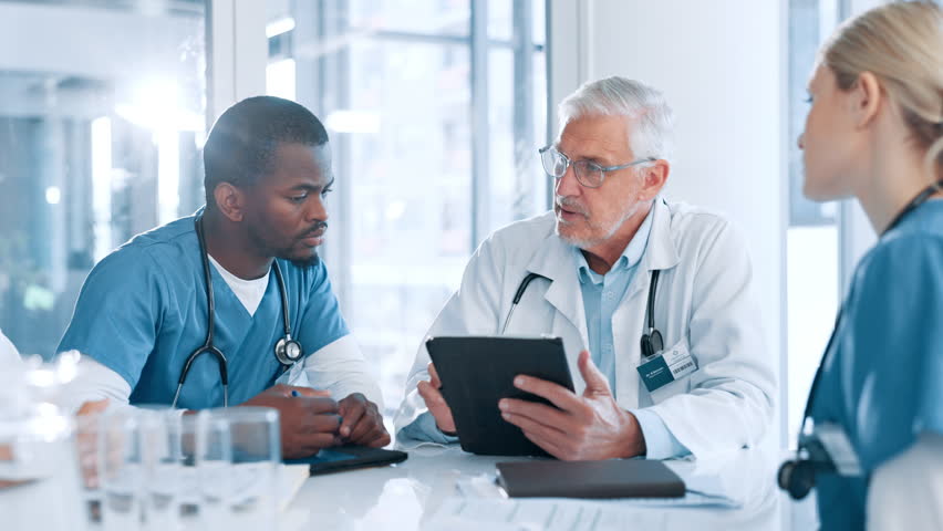 Medical, mature or doctors in meeting with tablet, planning or health treatment results in hospital. Group, teamwork or people in discussion for healthcare, clinic schedule and diagnosis research