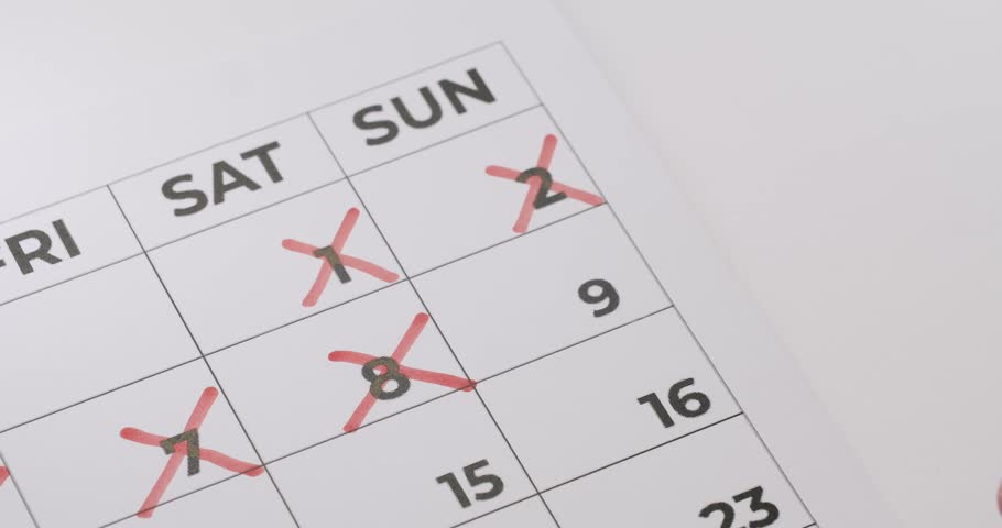 Close-up of a hand using a red marker to cross out dates on a calendar. The image emphasizes planning, scheduling, and organization. Perfect for illustrating deadlines and timelines.