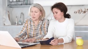 Adult daughter helps an elderly mother fill out passport information on website of state company on the Internet. High quality 4k footage - Powered by Shutterstock - Get 15% off with code: PIKWIZARD15
