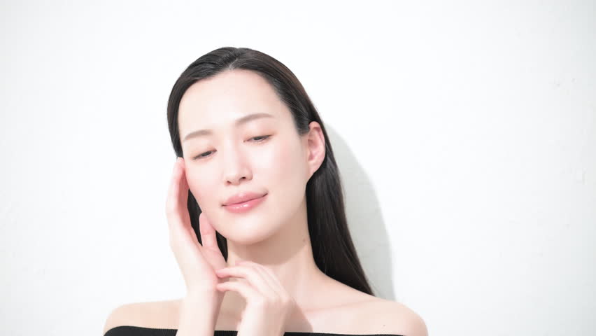 video of a frontal beauty image of a young woman with beautiful dark hair, glossy and bare skin, close eyes close-up.	
