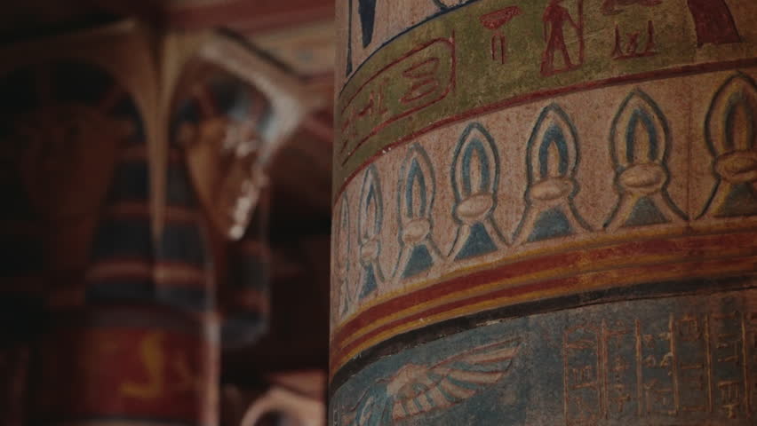 Close-up of ancient Egyptian pillars with hieroglyphics and colorful carvings. The intricate details and vibrant colors showcase the rich history and artistic skill of the era.