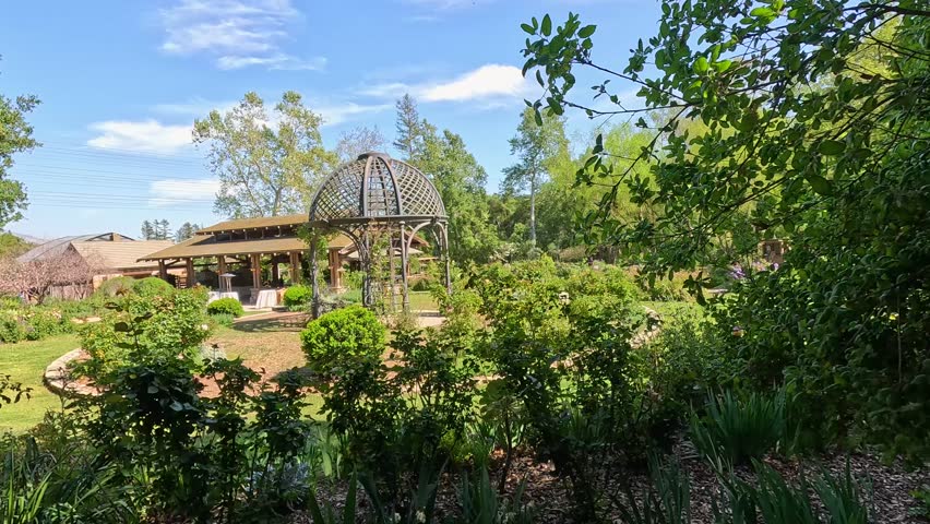 footage of a gorgeous spring landscape with a gazebo, colorful flowers and lush green trees and plants at Descanso Gardens La Canada Flintridge California USA