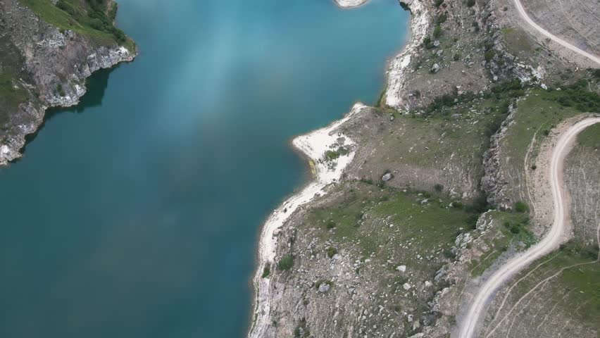 Lake in the mountains at sunset. Gizhgit lake in North Caucasus, Russia. Aerial top down view. Summer landscape. 

